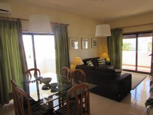 a living room with a table and a black couch at Quinta das Palmeiras - T2 in Porches