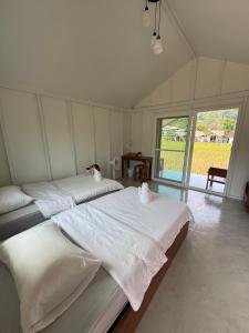 ein großes Schlafzimmer mit 2 Betten und einem großen Fenster in der Unterkunft สะปันดีวิว Sapan Dee View บ่อเกลือ น่าน in Ban Huai Ti
