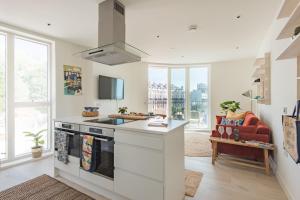 eine Küche mit weißen Arbeitsflächen und einem Herd mit Backofen in der Unterkunft The Perch at Shoreline in Folkestone