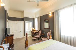 a bedroom with a bed and a table and chairs at Rutland Arms Inn in Whanganui