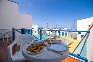 a table with a plate of food on a balcony at TAO El Cotillo - VV in El Cotillo