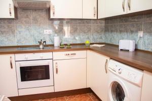 a kitchen with white cabinets and a washer at TAO El Cotillo - VV in El Cotillo