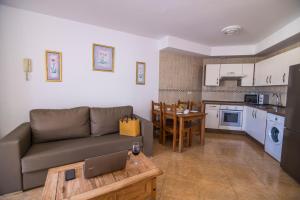 a living room and kitchen with a couch and a table at TAO El Cotillo - VV in El Cotillo