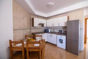 a kitchen with a table and chairs and a refrigerator at TAO El Cotillo - VV in El Cotillo