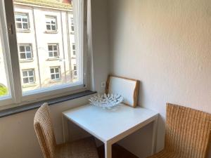 a table and two chairs in a room with a window at 2-Zimmer-Wohnung mit Balkon in der City in Nürnberg