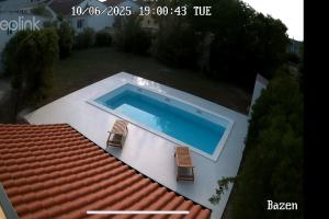 a swimming pool on top of a house with two chairs at Villa Paro in Pag
