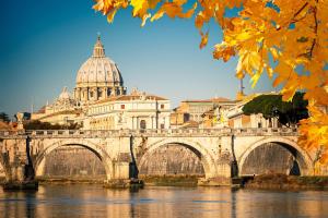 a bridge over a river with a cathedral at Tempio del Sole in Rome