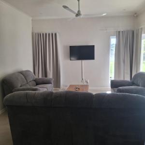 Una sala de estar con un sofá y un televisor de pantalla plana. en Eshowe Hills The 19th, en Eshowe
