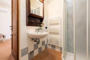 a bathroom with a sink and a mirror at CASALE TEATRO 10, Emma Villas in Laiatico +28 photos