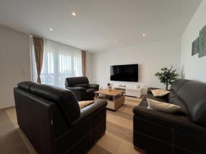 a living room with two leather couches and a flat screen tv at Villa Santolina in Maslenica