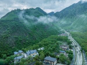 九寨沟Between Trees and Streams的享有带房屋和道路的山景 更多37张照片