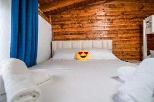 a bedroom with a bed with a smiley pillow on it at Kroni Apartments in Velipojë
