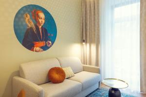 a living room with a couch and a painting of a woman at LeonArt Living 12 in Graz +31 photos