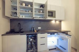 a kitchen with white cabinets and a dishwasher at LeonArt Living 12 in Graz