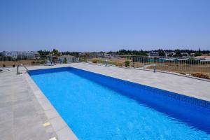 a large swimming pool with blue water at Latitudes 1 Bedroom Apartment in Meneou