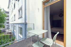 a balcony with a table and chairs and a bedroom at LeonArt Living 12 in Graz
