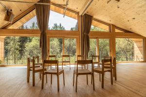 a dining room with a table and chairs and large windows at Naturhotel BASISLAGER Fichtelberg in Kurort Oberwiesenthal