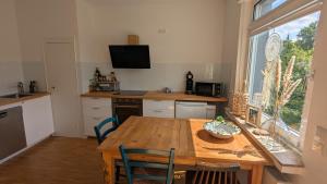 a kitchen with a wooden table and a kitchen with a window at Helle Ferienwohnung Aachen Süd in Aachen