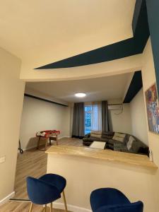 ein Schlafzimmer mit einem Bett und zwei blauen Stühlen in der Unterkunft Lomi's Homey - Rooms in Tbilisi City