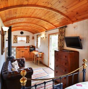 a living room with a couch and a tv at Finest Retreats - Shepherds Retreat at Morrells Wood in Shrewsbury