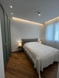 トラーニにあるCharmante Wohnung in Traniの白いシーツと窓のあるベッドのある寝室