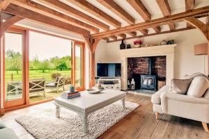 a living room with a table and a fireplace at Finest Retreats - Windfall Cottage in Tewkesbury