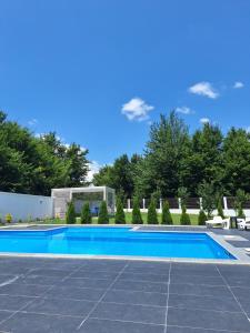a blue swimming pool in a yard with trees at Villa Arkado in Sarajevo
