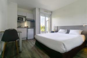 谢勒谢勒城市公寓酒店的一间带一张白色大床的卧室和一间厨房