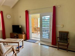 クラレンダイクにあるCaracara L3 Relax & Dive Resort Bonaire Villageのリビングルーム(赤いカーテン、ガラスの引き戸付)