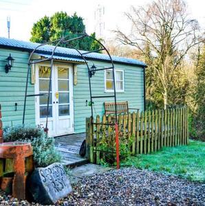 a small blue house with a gate and a fence at Finest Retreats Shepherds Rest at Morrells Wood in Shrewsbury