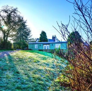 a house on a grassy hill with a yard at Finest Retreats Shepherds Rest at Morrells Wood in Shrewsbury