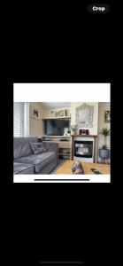 a living room with a couch and a mouse on a table at Haven Holiday Park Orchards in Saint Osyth +6 photos
