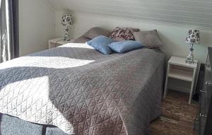 a bed with two pillows on it in a bedroom at 3 Bedroom Awesome Home In Gursken in Larsnes +17 photos