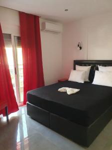 a bedroom with a black bed with red curtains at Apartments Vesna Luxury & Stefan Ap 10 in Paralia Katerinis