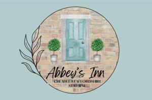 a brick wall with a blue door and two trees at Abbey’s Inn in Cheadle