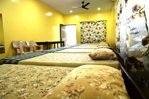 a row of beds in a room with yellow walls at Socials by bablos in Molem