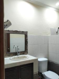 un bagno con lavandino, WC e specchio di Bali Villa coral ad Amed