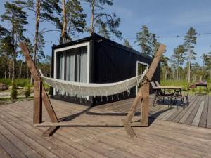 a hammock on the deck of a tiny house at Männikumereääre with sea view and private beach in Kõrgessaare