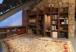 a living room with wooden bookshelves and a rug at Oak Hill Gerês, Portugal in Terras de Bouro