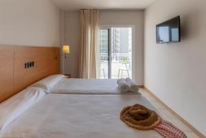 a bedroom with a large white bed with towels on it at Bay Hotel in Roses +42 photos