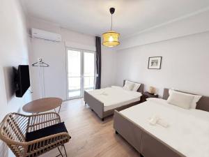 アテネにあるAlimos Apartment near Edem Beach and the Sea with 2 Bedroomのベッド2台とテーブルと椅子のある部屋