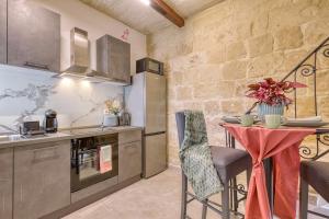 a kitchen with a table and a counter top at Jade - Stylish Zabbar Hideaway in Żabbar