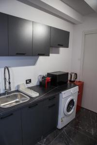 a kitchen with a sink and a washing machine at 3 Rooms Catania - Vulcano bright independent studio apartment in Catania