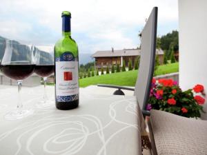 a bottle of wine sitting on a table with two glasses at Appartement Riedmann in Brixen im Thale