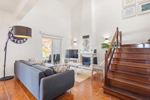 a living room with a couch and a staircase at Pool-Golf-Ocean resort home in Praia Del Rey in Amoreira