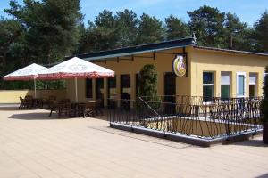 库瑞尼卡慕斯卡Luxus的露台上摆着桌子和遮阳伞的餐厅