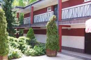 库瑞尼卡慕斯卡Luxus的一栋带阳台的建筑，还有一些树木和灌木丛