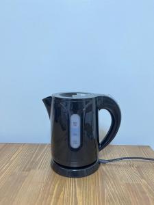 eine schwarze Kaffeekanne auf einem Holztisch in der Unterkunft YadoPAP Ina town 宿ぱっぷ伊奈町 in Ina
