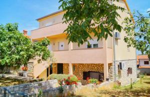 a large house with a tree in front of it at Apartment Leni 2 in Banjole +1 photo