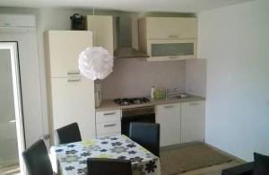 a kitchen with a table and a kitchen with a white refrigerator at Apartment Leni 2 in Banjole